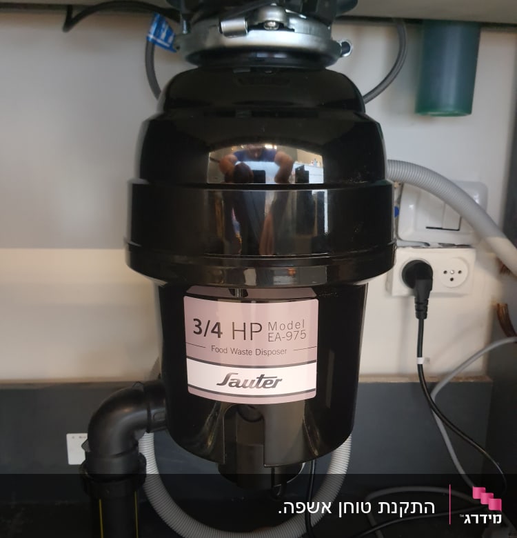 מטחנת אשפה מתחת לכיור עם צינורות חיבור